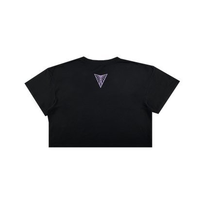 The Women's Golden State Valkyries Balloons Crop Tee by GSV is shown from the back in black, featuring a small purple geometric emblem near the neckline on a plain background. No other designs or text are visible; background is white.