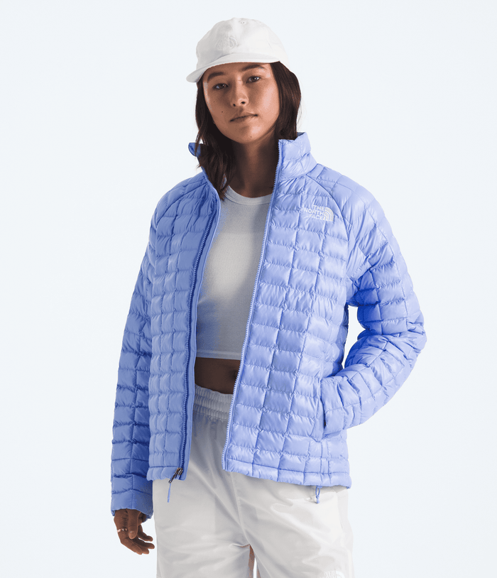 Person wearing a light blue puffer jacket on a white background