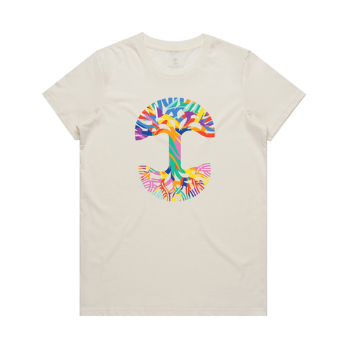 The Women's Urban Tropics Tee by Oaklandish is a cream-colored shirt with a bold abstract "T" on the chest, showcasing Kalani Ware’s vibrant multicultural design in blue, orange, yellow, green, pink, and purple hues.