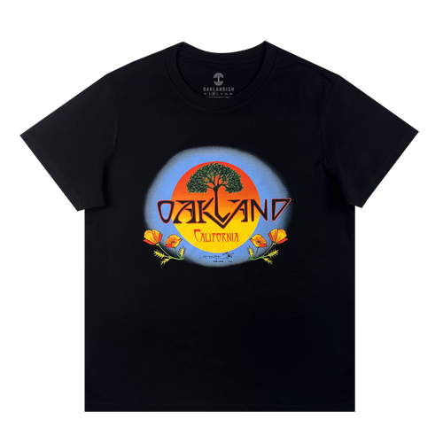 The Oaklandish Women's Vanguard Tee is a cotton t-shirt with a bold tree, orange sun, and poppy flowers graphic. "Oakland" stands over "California" in yellow inside a blue circle, inspired by Stanley Mouse art.