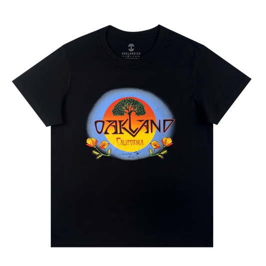 The Oaklandish Women's Vanguard Tee is a cotton t-shirt with a bold tree, orange sun, and poppy flowers graphic. "Oakland" stands over "California" in yellow inside a blue circle, inspired by Stanley Mouse art.