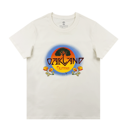 The Oaklandish Women's Vanguard Tee is a classic fit featuring a round sunset graphic with a black tree, bold "OAKLAND," "California" below, and orange poppies framing the border.