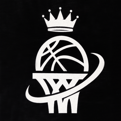 The WPBA Core LS Tee by Oaklandish showcases a stylized white basketball on a black background, featuring a basketball resting on a hoop with a swoosh wrapping around both. A simple five-pointed crown above the ball signifies grandeur or royalty, evoking empowerment in women's sports.